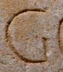 A close-up of an instance of allograph   inscribed on an object