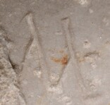 A close-up of an instance of allograph   inscribed on an object