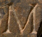 A close-up of an instance of allograph   inscribed on an object