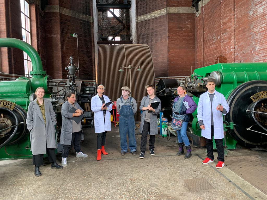 A group of people standing proudly alongside a majestic steam engine