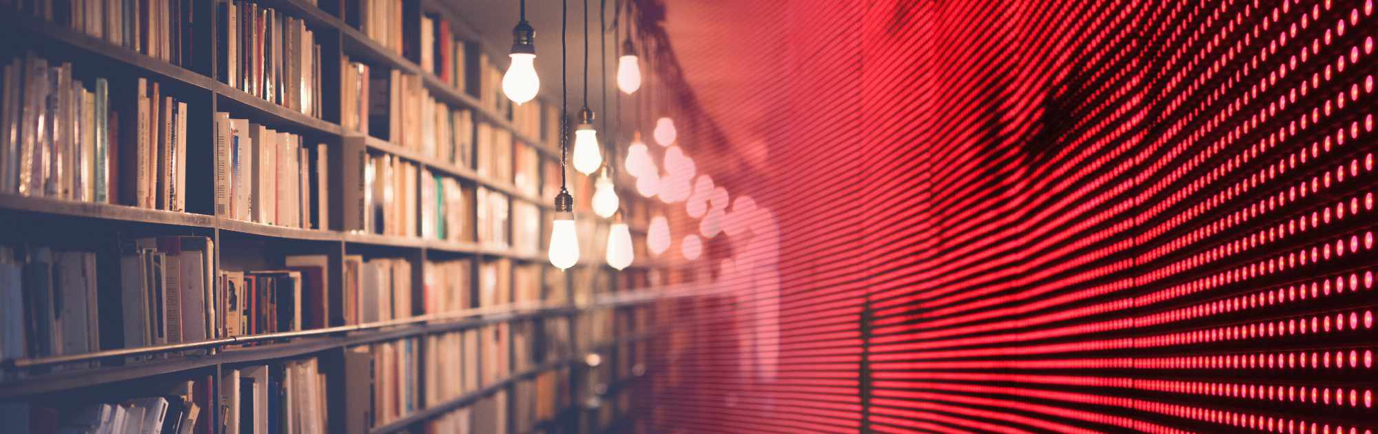 Library shelves filled with books on the left side, with a red LED light wall on the right