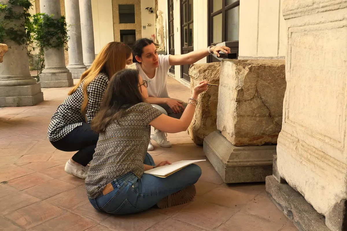 Threes researchers reading an ancient inscription